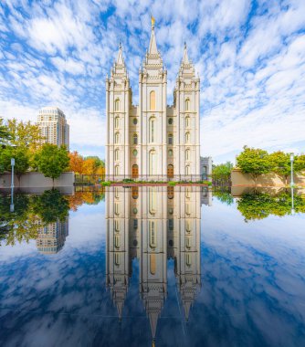 Tapınak meydanındaki İsa 'nın Son Günü Kilisesi' nin ünlü Salt Lake Tapınağı 'nın klasik panoramik manzarası. Sonbaharda güneşli bir günde güzel yansımaları olan Salt Lake City, Utah, ABD