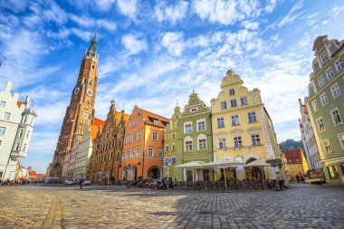 Geleneksel renkli evleri ve ünlü St. Martin Kilisesi ile tarihi Landshut kasabasının manzaralı panoramik manzarası. Güzel güneşli bir günde mavi gökyüzü ve bulutlar yazın, Bavyera, Almanya