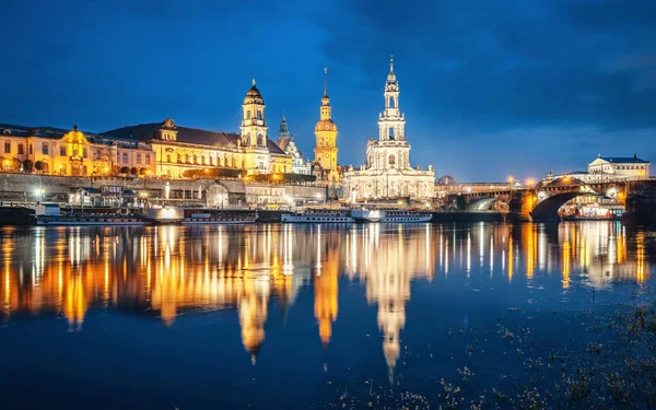 Dresden 'in tarihi şehir merkezinin panoramik manzarası. Kutsal Üçlü' nün ünlü katedrali, yazın alacakaranlıkta güzel Elbe nehrine yansıyor.