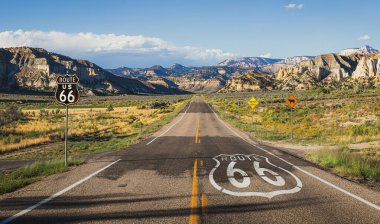 Ünlü Route 66 'nın manzaralı panoramik manzarası. Tarihi sokak işaretleri ve tabelaları klasik Amerikan vahşi batı dağ manzarasında gün batımında güzel altın akşam ışığı altında.