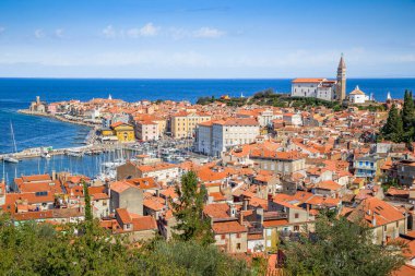 Antik Piran 'ın tarihi şehir merkezinin güzel hava manzarası ünlü Aziz George ve Tartini Meydanı Kilisesi güneşli bir günde mavi gökyüzü ve yazın bulutlar, Prian Körfezi, Istria, Slovenya