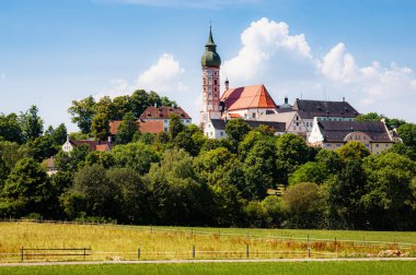 Tarihi kilise kulesi ve güzel güneşli bir günde tepede ünlü bir bira fabrikası olan eski huzurlu Andechs Abbey 'in manzarası. Yazın mavi gökyüzü, Starnberg bölgesi, Yukarı Bavyera, Almanya