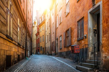 Klasik manzara manzarası Prstgatan (The Priest 's Street) Stockholm' ün tarihi Gamla Stan kasabasında geleneksel renkli evler güzel altın sabah ışığı, Stockholm, İsveç
