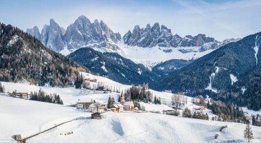 Ünlü Dolomites dağ zirvelerinin klasik panoramik manzarası cennet köyü Val di Funes ve tarihi St. Magdalena Kilisesi kışın mavi gökyüzü, Güney Tyrol, İtalya 'da güneşli bir günde