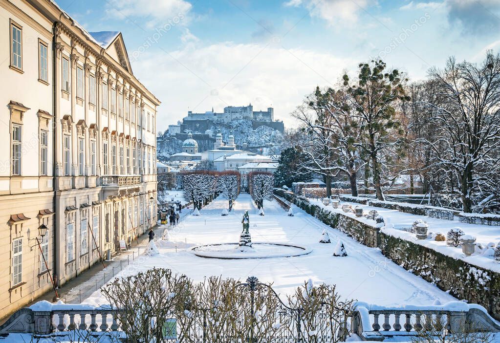 Classic view of famous Mirabell Gardens in the historic city of Salzburg with Hohensalzburg Fortress in golden evening light on a beautiful sunny day with blue sky in winter, Salzburger Land, Austria