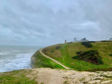 İngiltere 'nin Dorset kentindeki Jurassic sahilinin bir parçası olan Swanage' da kumtaşı kaya ve kayaların üzerine dalgalar düşüyor.