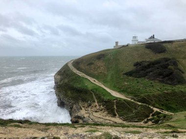 İngiltere 'nin Dorset kentindeki Jurassic sahilinin bir parçası olan Swanage' da kumtaşı kaya ve kayaların üzerine dalgalar düşüyor.
