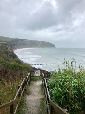 İngiltere 'nin Dorset kentindeki Jurassic sahilinin bir parçası olan Swanage' da kumtaşı kaya ve kayaların üzerine dalgalar düşüyor.