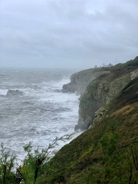 イングランドのドーセットにあるジュラ紀の海岸の一部であるSwanageの砂岩岩や岩に衝突する波 — ストック写真