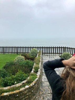 Swanage, Dorset / England: 01 / 29 / 2020 Jurassic Coast 'un bir parçası olan tepelere ve kayalıklara doğru Swanage Bay' deki Pines otelinin çimlerinin üzerinde güzel bir uçurum manzarası.