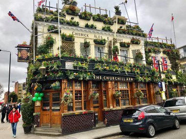 LONDON, İngiltere - 29 Aralık 2019: Londra 'daki Churchill Arms' ın dış görünüşü. Dış yüzeyde büyük miktarlarda çiçek ve İngiltere süslemeleri görülebilir..