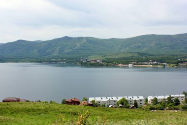 Harika bir panoramik manzara. Puslu, görkemli dağların ortasında temiz bir dağ gölü.