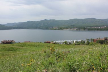 Harika bir panoramik manzara. Puslu, görkemli dağların ortasında temiz bir dağ gölü.