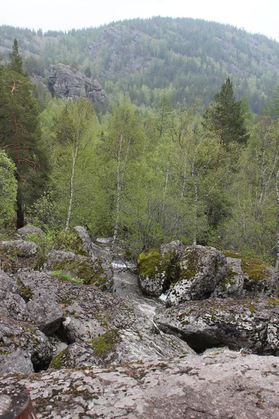 Vista superior. Uma cachoeira de rio de montanha flui através de um leito de rio através de enormes pedras com musgo — Fotografia de Stock
