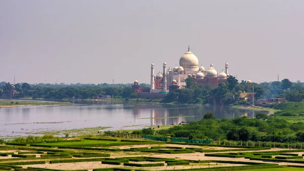 ムガル皇帝シャー ジャハーンによって1643年に建てられたタージ マハル廟の遠望は インドのアグラのヤムナ川の隣にある妻ムムタズ マハルの墓を収容するために建てられました — ストック写真