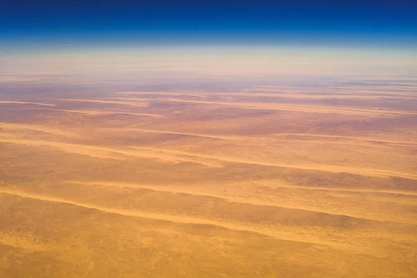 Aerial airplane view of barren Sahara desert landscape in Egypt