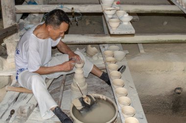 Jingdezhen, Jiangxi vilayeti / Çin - 29 Mayıs 2014: Çin 'in Jingdezhen kentindeki Çömlekçilik atölyesinde çalışan Porselen Sanatçısı, porselen üretimiyle ünlü ve dünyanın Porselen Başkenti olarak bilinen şehir