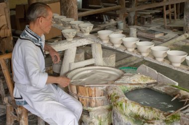 Jingdezhen, Jiangxi vilayeti / Çin - 29 Mayıs 2014: Çin 'in Jingdezhen kentindeki Çömlekçilik atölyesinde çalışan Porselen Sanatçısı, porselen üretimiyle ünlü ve dünyanın Porselen Başkenti olarak bilinen şehir