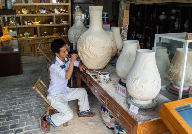 Jingdezhen, Jiangxi vilayeti / Çin - 29 Mayıs 2014: Çin 'in Jingdezhen kentindeki Çömlekçilik atölyesinde çalışan Porselen Sanatçısı, porselen üretimiyle ünlü ve dünyanın Porselen Başkenti olarak bilinen şehir