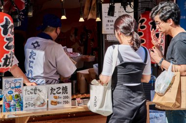Osaka / Japonya - 21 Mayıs 2018: Takosen satan sokak gıda satıcısı, Japonya 'nın Osaka bölgesindeki Dotonbori bölgesinde Takoyaki ahtapot toplarıyla dolu iki Senbei pirinç krakerinden oluşan sandviçler