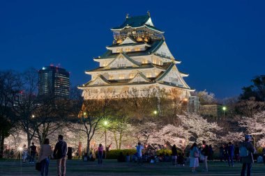 Osaka / Japonya - 28 Mart 2018: İnsanlar Osaka Şatosu, Japonya 'daki Nishinomaru bahçesinde kiraz çiçekleri yozakura ve piknik izleyerek eğleniyorlar.