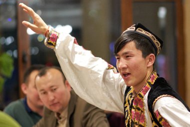 Pekin / Çin - 10 Nisan 2016: İnsan Pekin, Çin 'deki bir Uygurca restoranında geleneksel Uygurca dansı yapıyor