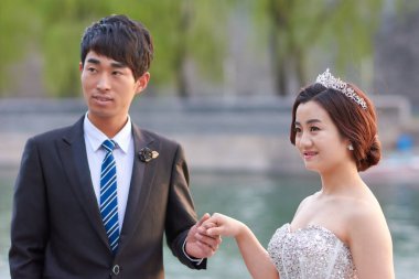 Pekin / Çin - 7 Nisan 2016: Çin 'in Pekin kentindeki Yasak Şehir (Saray Müzesi) önünde poz veren sevimli Çinli düğün çifti