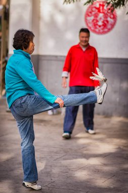 BEIJING / ÇİN - 3 Nisan 2016: Geleneksel Çin sporu olan Jianzi oynayan insanlar, oyuncuların ağır ağırlıklı bir mekik sikini havada tutmayı hedefledikleri Çin, Pekin, Çin