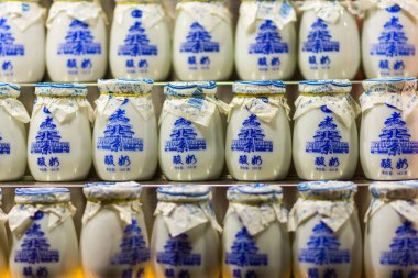 Pekin / Çin - 17 Temmuz 2016: Lao Beijing Suannai 'nin fincanları, eski usul Pekin yoğurdu, sıcak süt, şeker ve fındık ve kuru üzüm karışımı ile yapılan popüler yoğurt.
