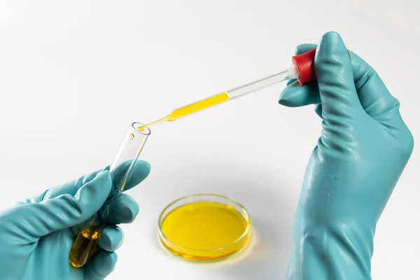 Laboratório de testes conta-gotas laboratório com teste de fluido amarelo em Petri Fotos De Bancos De Imagens