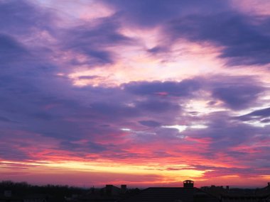 Bacalı ve çatılı evlerin karanlık, berrak siluetleri.
