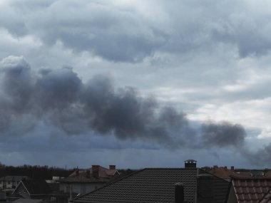 Gökyüzünde ateşten siyah dumanlar yükseliyor. Kirlenme... 