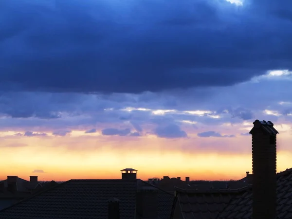 Mörka, klara siluetter av taken på hus med skorstenar och — Stockfoto