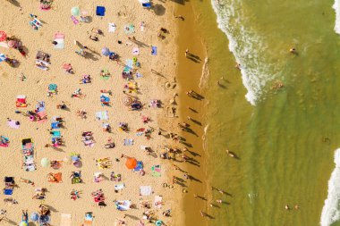 Bir İHA 'nın hava görüntüsü. Kumsalda turistler, güneşlikler ve odunlar