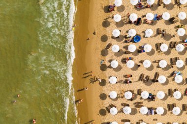 Bir İHA 'nın hava görüntüsü. Kumsalda turistler, güneşlikler ve odunlar