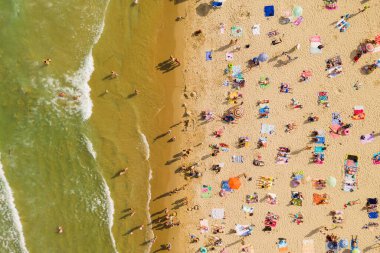 Bir İHA 'nın hava görüntüsü. Kumsalda turistler, güneşlikler ve odunlar