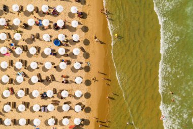 Bir İHA 'nın hava görüntüsü. Kumsalda turistler, güneşlikler ve odunlar
