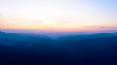 Gün batımında dağın tepeleri batan güneşin arka planına karşı. T