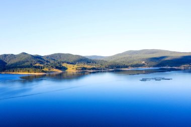 Bulgaristan 'da ormanlarla çevrili göl ve dağlar. Göldeki balık çiftlikleri ve diğer balıklar. Bir İHA ile havadan çekim