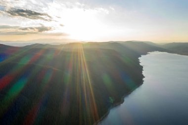 Bulgaristan 'da batan güneşin renkli ışınlarıyla çevrili göl ve dağlar. Balık çiftlikleri alabalığı ve göldeki diğer balıklar. İnsansız hava aracı ile hava görüntüsü
