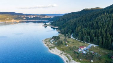 Dağların ve gölün manzarası, Bulgaristan. Ormanlarla çevrili dağ gölleri, İHA kullanarak havadan çekilen görüntüler.