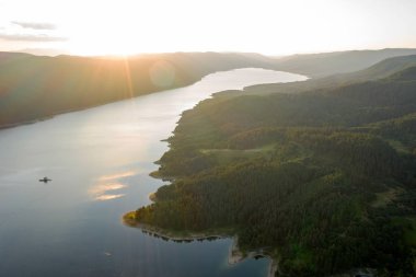 Bulgaristan 'da batan güneşin renkli ışınlarıyla çevrili göl ve dağlar. Balık çiftlikleri alabalığı ve göldeki diğer balıklar. İnsansız hava aracı ile hava görüntüsü