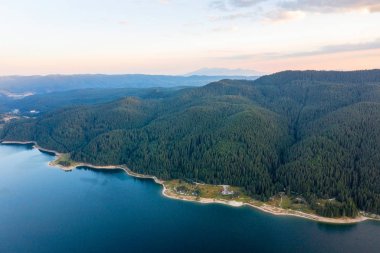Dağların manzarası ve Bulgaristan 'ın sisli gölü. Ormanlarla çevrili dağ gölleri, İHA kullanarak havadan çekilen görüntüler.