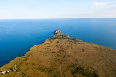 Kaliakra 'nın dar ve uzun burnu Bulgaristan' ın kuzey kıyısında denize açılıyor. Kırmızımsı bir rengin yüksek dik kıyıları çimlerin yeşilliği ve sonsuz mavi denizle uyum içindedir. İnsansız hava aracından görüntüle.