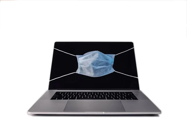 MacBook gibi yüz maskeli dizüstü bilgisayar salgın korumasını gösteriyor