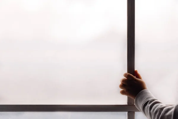 Pencereyi tutan çocuk tasarım için yeri olan yağmurlu pencerenin yanında duruyor