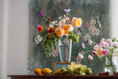 Yeşil çiçekli vazoda kırmızı sarı ve turuncu bahar çiçekleri.