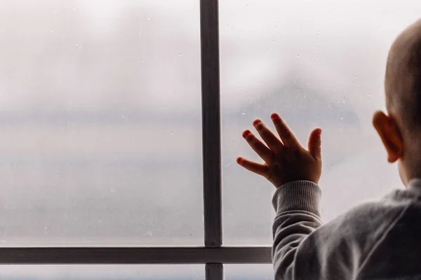 Gyermek tartó ablak üveg közelében áll esős ablak helyet a design Stock Kép