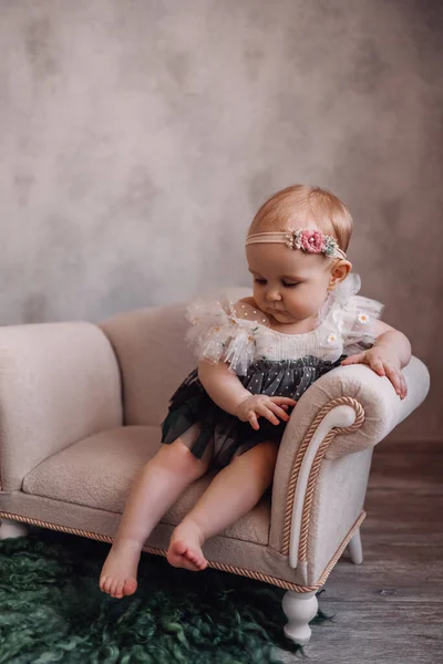 Cute newborn baby on sofa. Infant girl sitting on special little baby furniture