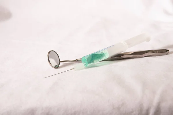 Diş hekimleri ayna ve şırıngayı kapatır. 